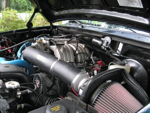 1994 Ford Bronco - Close-up view of an engine bay an aftermarket K&N air intake system and a silver intake manifold.
