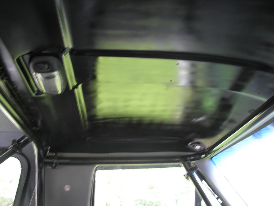 Interior roof of a vehicle with a black headliner and a light fixture