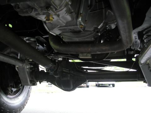 1994 Ford Bronco - A detailed view of the vehicle's undercarriage, focusing on the drivetrain and exhaust components.