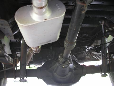 1994 Ford Bronco - The undercarriage of a vehicle is captured, revealing its mechanical components and a visible brand name on the muffler.
