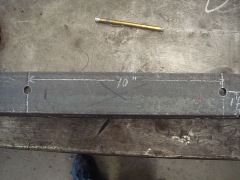 1996 Ford Bronco - A metal bar is marked with chalk lines and holes, possibly for fabrication or installation.