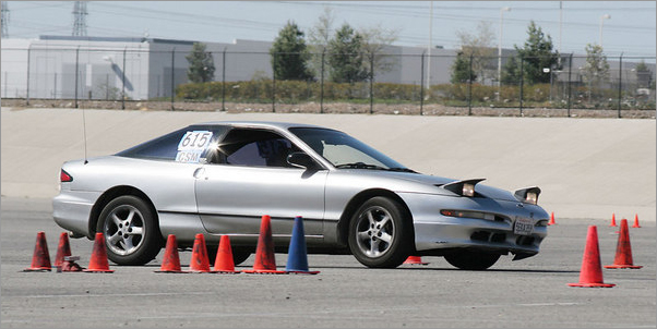Silver Ford Probe autocrossing through cones with number 615 on the door