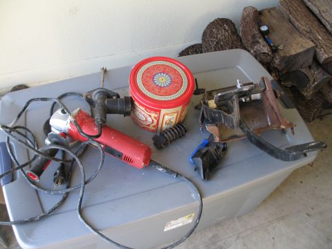 1995 Ford Bronco - Various parts and tools are laid out on a storage container next to a stack of firewood.