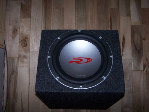 1995 Ford Probe - Alpine R-Series 12-inch subwoofer in a carpeted enclosure, likely for a car audio system.