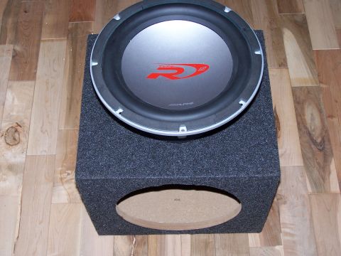1995 Ford Probe - Subwoofer with red 'R' logo on a carpeted box, on a wooden floor.
