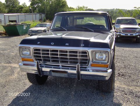 1978 Ford Bronco - A black 1978 Ford Bronco is parked on a gravel lot, with another truck visible in the background.