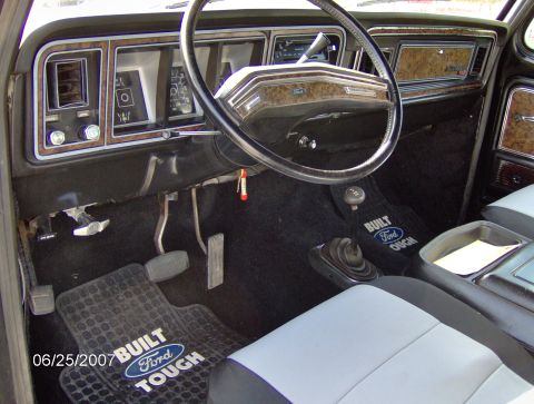 1978 Ford Bronco - Interior view of a 1978 Ford Bronco, the dashboard, steering wheel, and floor mats.