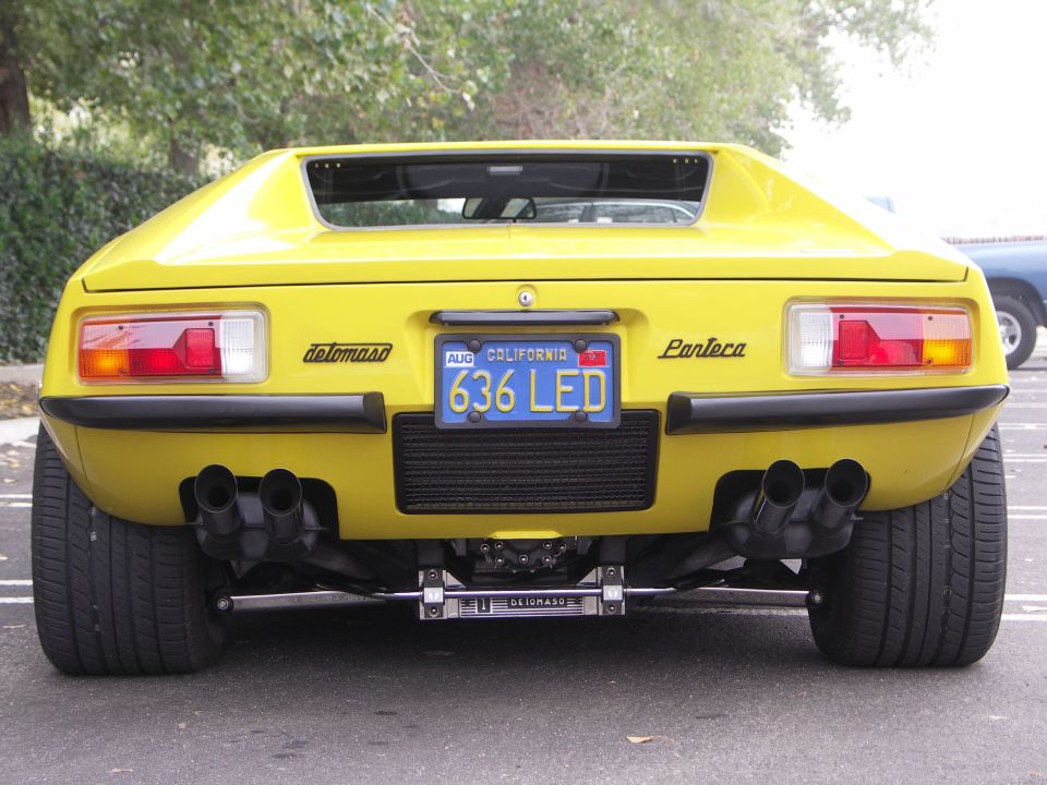 Rear view of yellow DeTomaso Pantera with quad exhaust and California plate 636 LED