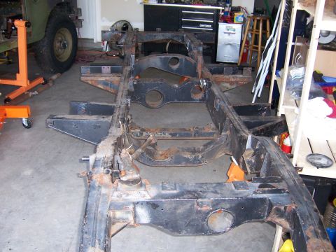 1974 Land Rover Land Rover - A heavily rusted vehicle chassis is undergoing restoration in a garage setting.