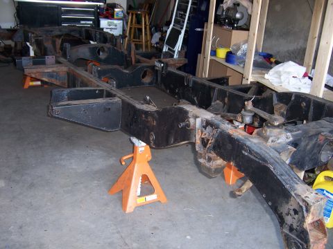 1974 Land Rover Land Rover - The chassis of a vehicle is supported by jack stands, indicating it is undergoing restoration or repair.