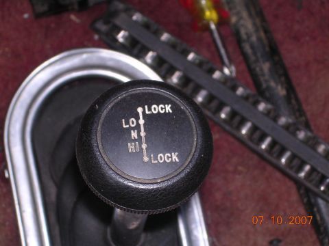 1978 Ford Bronco - Close-up of a transfer case shifter knob showing gear positions.
