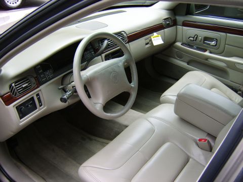 1996 Mercury Grand Marquis - The interior of this car features tan leather seats, a wood-trimmed dashboard, and a prominent steering wheel.