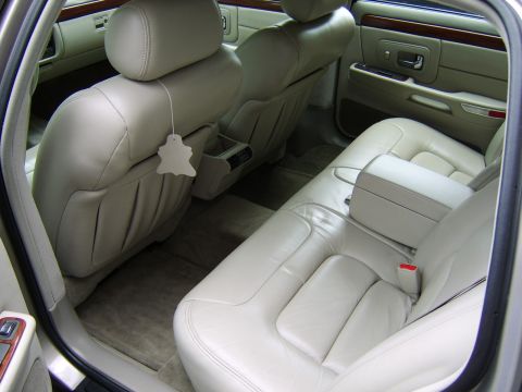 1996 Mercury Grand Marquis - The interior of a car shows beige leather seats and wood trim details.