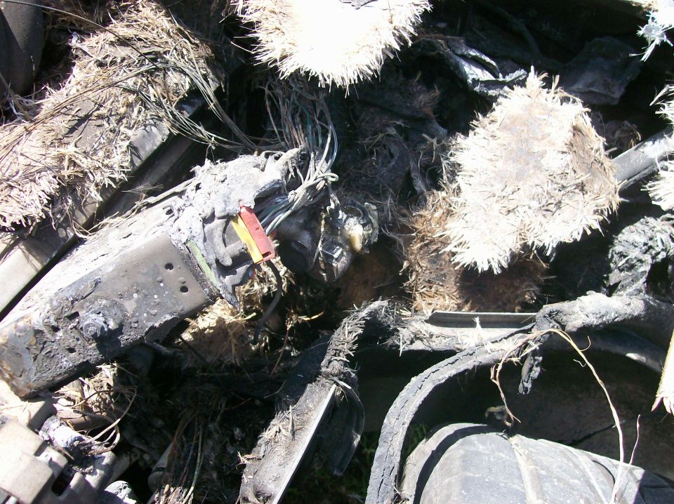 Burnt engine compartment with exposed wires and melted components