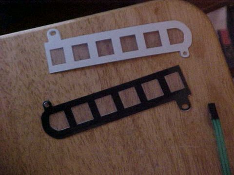 1995 Ford Taurus - Two metal strips with square cutouts are shown on a wooden surface.