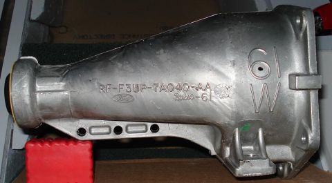 1999 Ford Crown Victoria - Passenger-side view of a cast aluminum Ford automatic transmission extension housing sitting on cardboard, with the casting number RF-F3UP-…