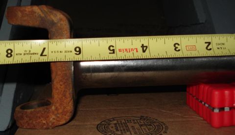 1999 Ford Crown Victoria - A driveshaft slip yoke lying on cardboard with a yellow Lufkin tape measure held along it, spanning roughly 8 inches from the U-joint ear t…