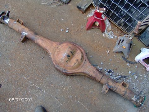 1978 Ford Bronco - A rusty rear axle assembly sits on the ground, with several jack stands visible in the background.