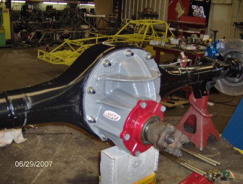 1978 Ford Bronco - Close-up of a rear axle assembly, likely undergoing a disc brake installation, in a workshop setting.