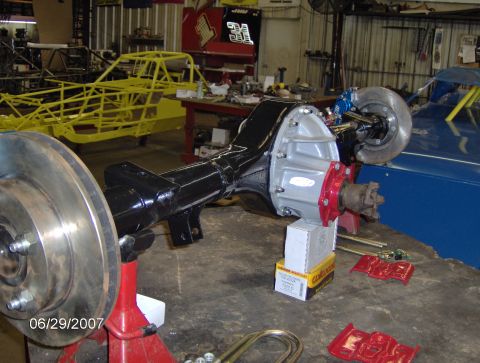 1978 Ford Bronco - A rear axle assembly with disc brakes is shown on jack stands in a workshop setting.