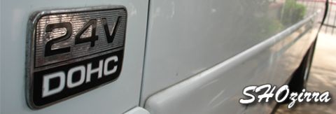 1993 Ford Taurus - A close-up of a 24V DOHC badge on the side of a white vehicle, with a watermark visible.