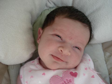 2000 Ford Crown Victoria - A baby with dark hair smiles while lying down.
