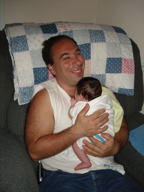 2000 Ford Crown Victoria - A man smiles while holding a baby wrapped in a blanket.