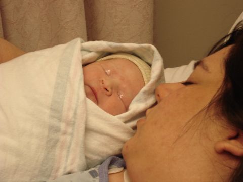 2000 Ford Crown Victoria - A mother gazes lovingly at her newborn baby, swaddled in a blanket.