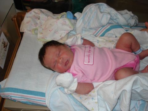 2000 Ford Crown Victoria - A newborn baby sleeps peacefully, adorned with a onesie that reads 'worth the wait'.