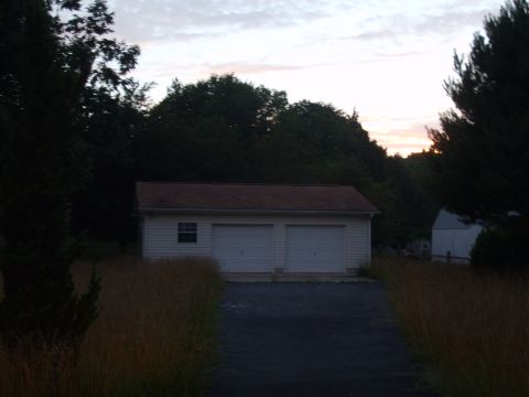 2004 Ford Crown Victoria - A suburban scene depicts a detached garage with two white doors under a dusky sky.