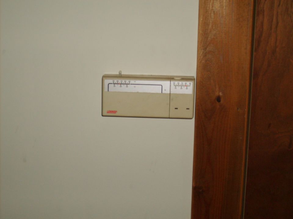 Beige thermostat with temperature settings and a blank label area