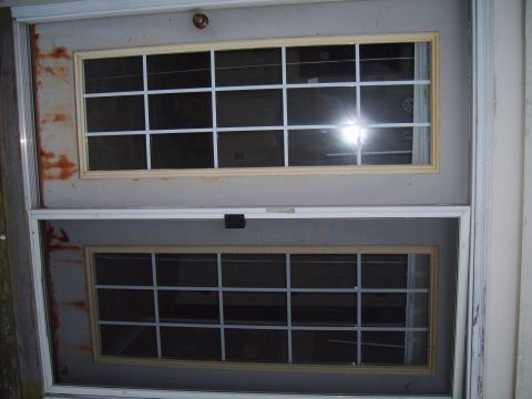 2004 Ford Crown Victoria - Double door with two paneled windows, one above the other, showing reflections.