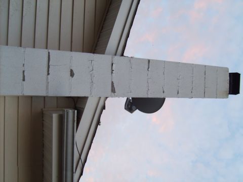 2004 Ford Crown Victoria - A close-up view of a cracked exterior beam with a light fixture, against a pale sky.