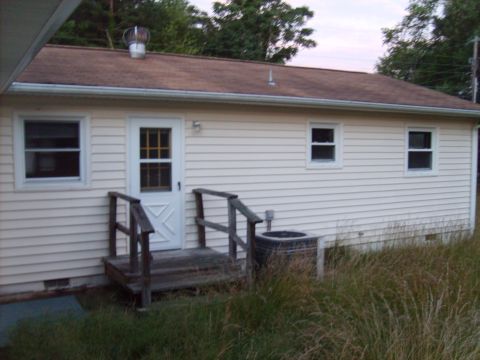2004 Ford Crown Victoria - The rear exterior of a house vinyl siding, a wooden deck, and an air conditioning unit, with a Supermotors.net logo in the corner.