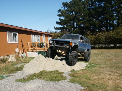 1993 Ford Bronco - A modified Toyota 4Runner is parked on a mound of gravel in front of a house.