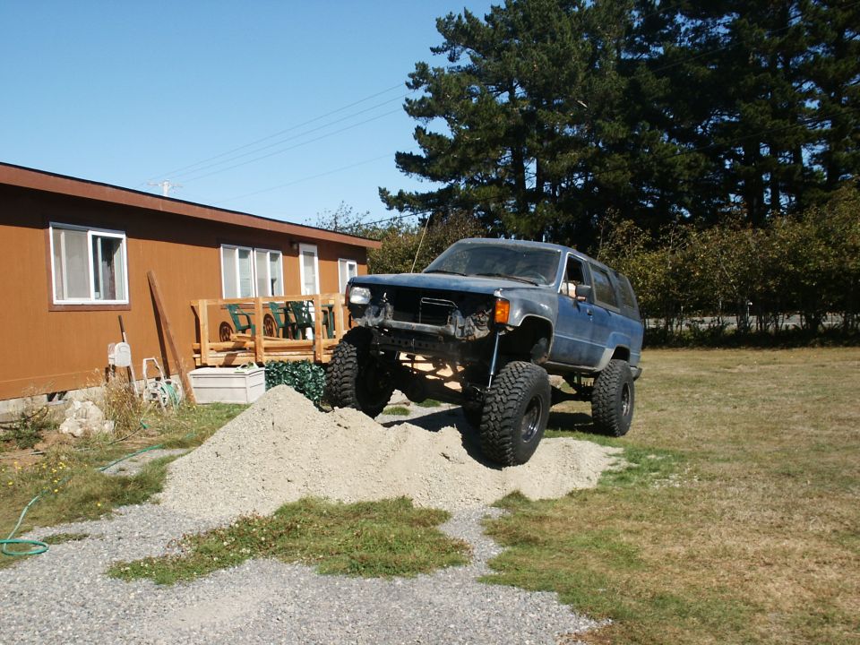 Blue Toyota 4Runner with lifted suspension and large tires on a pile of gravel