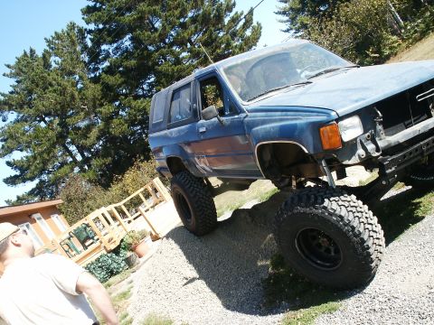 1993 Ford Bronco - This modified SUV, likely a Toyota 4Runner from the mid-1980s, is shown with significant suspension lift and large tires.