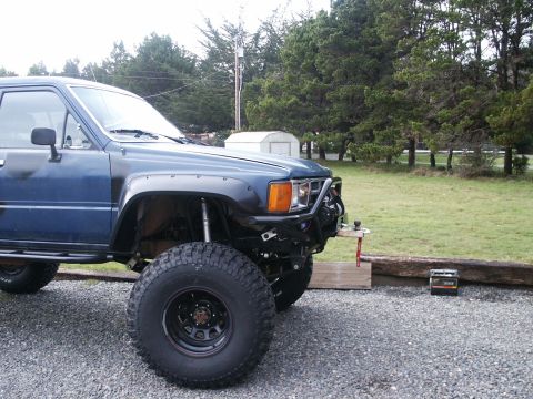 1993 Ford Bronco - Modified blue Toyota pickup truck parked outdoors with aftermarket bumper.
