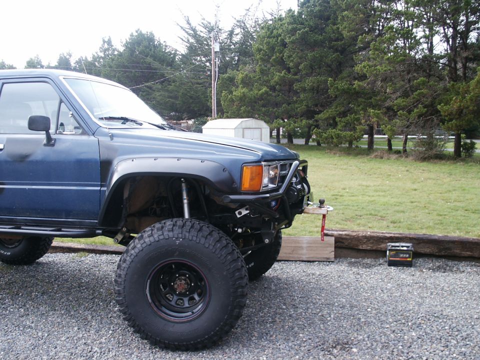 blue Toyota pickup truck with fender flares and large tires