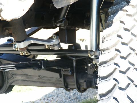 1993 Ford Bronco - Vehicle suspension parts and a large off-road tire are visible in this close-up shot.