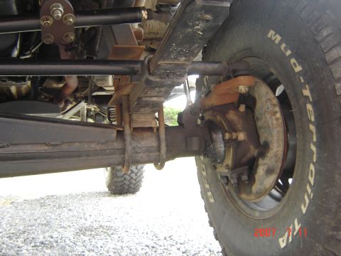 1993 Ford Bronco - Close-up view of the suspension and tire of an off-road vehicle.