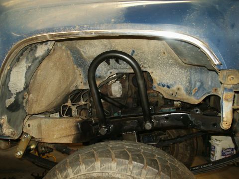 1993 Ford Bronco - Aftermarket roll cage installed in the rear wheel well, showing suspension and tire details.