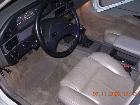 1995 Ford Taurus - The interior of a 1995 Ford Taurus is visible, including the dashboard and seats.