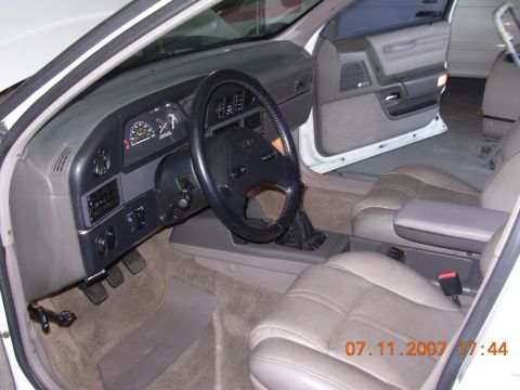1995 Ford Taurus - The interior of a 1995 Ford Taurus shows tan leather seats and a gray dashboard with visible gauges.
