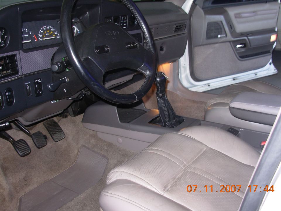 1995 Ford Taurus interior showing dashboard, steering wheel, gear shifter, pedals, and passenger seat