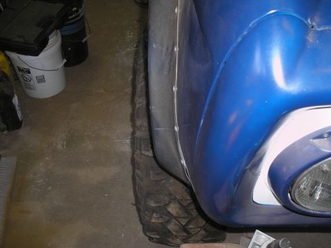 1966 Ford Bronco - Detail shot of a blue vehicle's fender and tire, with a Supermotors.net watermark.