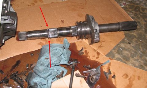 1978 Ford Bronco - A metal shaft with splines and a flange is shown, with red arrows indicating wear marks on the shaft.