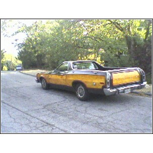 1973 Ford Ranchero - This 1973 Ford Ranchero pickup truck is parked on a residential street with trees in the background.
