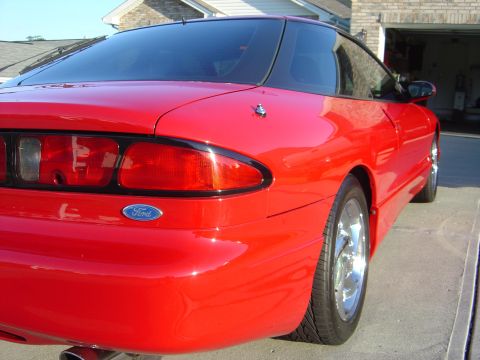1997 Ford Probe - The rear quarter panel and taillight assembly of a red Ford Probe are visible.