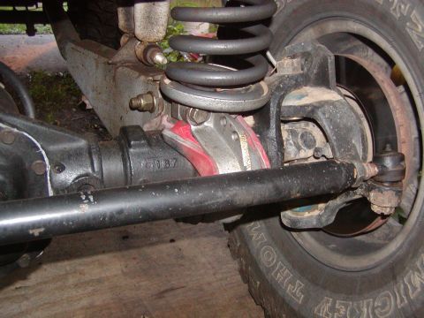 1991 Ford Bronco - This photo shows the rear axle and suspension components of a vehicle, including the coil spring and tie rod.